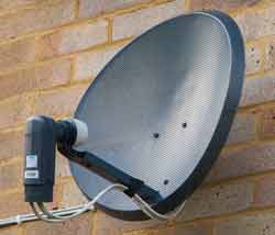 Domestic satellite television parabolic reflector antenna with an offset feed to reduce aperture block.