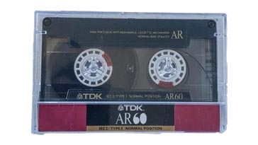 A typical audio cassette tape in its protective plastic case
