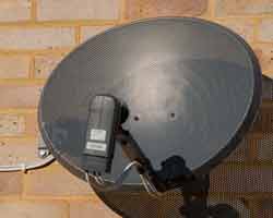 A domestic satellite television parabolic reflector antenna showing the offset feed arrangement to reduce aperture block which reduces the antenna gain.